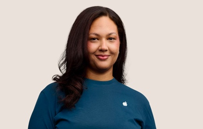 Portrait of a smiling Apple Retail team member with long dark hair.