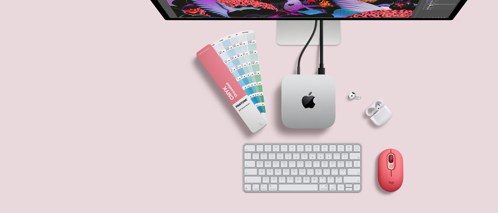 Mac mini, από πάνω, ασημί αλουμίνιο, στρογγυλεμένες γωνίες, γυαλιστερό μαύρο λογότυπο Apple στο κέντρο, συνδεδεμένο με καλώδιο, οθόνη Studio Display μερική ορατότητα από πάνω, AirPod 4, ανοιχτά, δείγματα χρωμάτων Pantone, αριθμητικό πληκτρολόγιο και ποντίκι