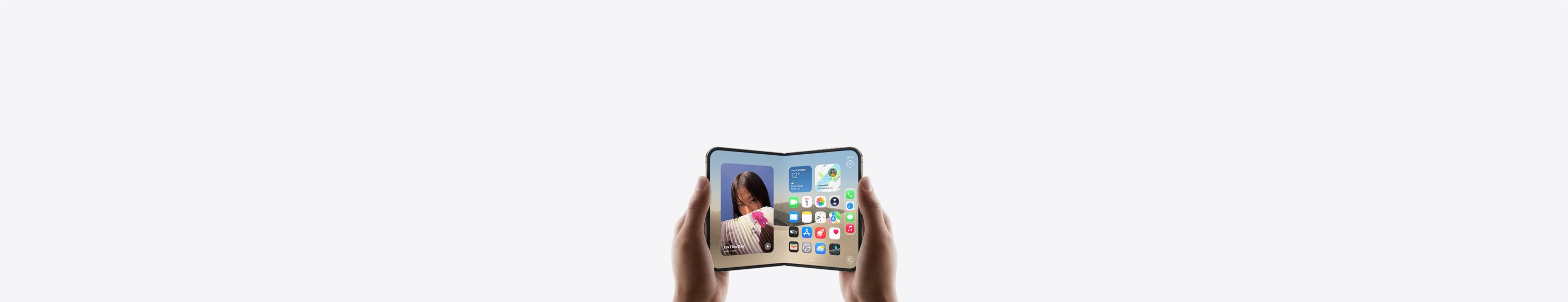 „iPhone Duo“, horizontaliai laikomas dviem rankomis, atlenktas, vidiniame ekrane matomas pradžios ekranas