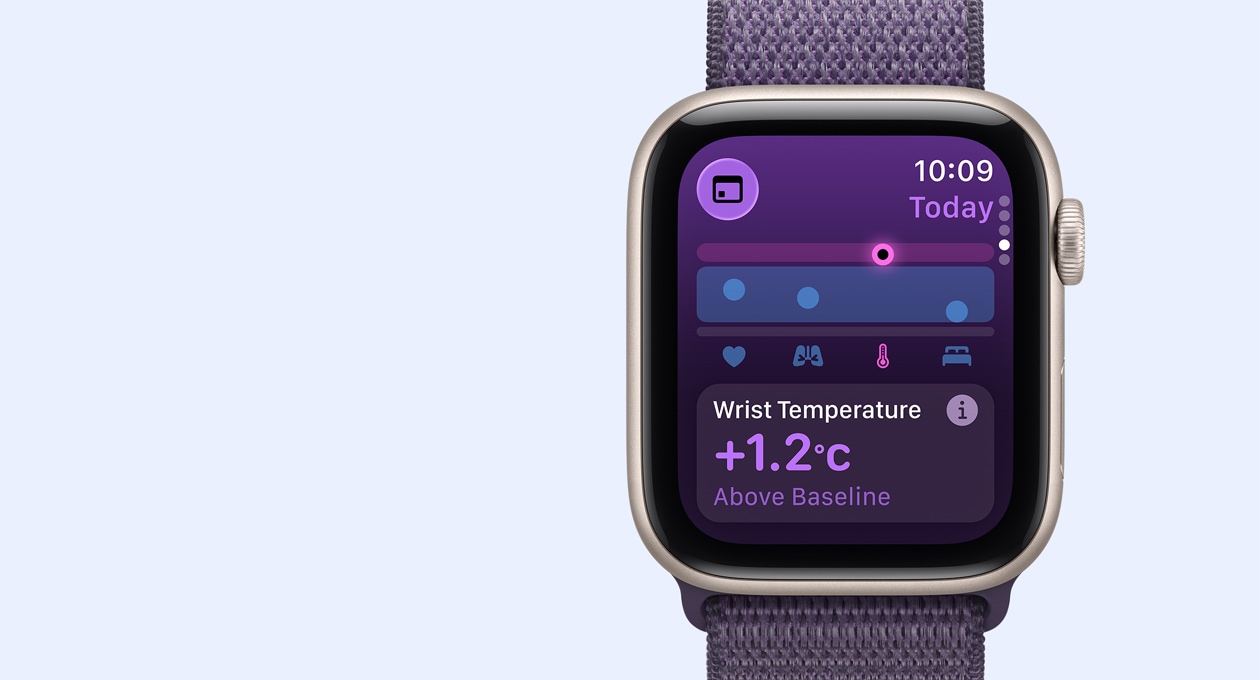 Apple Watch SE 3 z aluminiową kopertą w kolorze księżycowej poświaty i opaską sportową w kolorze mlecznego fioletu. Ekran pokazuje wskaźniki temperatury nadgarstka. Na prawym boku urządzenia pokrętło Digital Crown