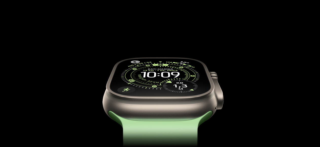 Natürel titanyum kasaya sahip ve neon yeşil renkte Ocean kordonla eşleştirilmiş Apple Watch Ultra 3’ün etkileyici fotoğrafında Yön Bulma özellikli kadrandaki pusula gösteriliyor.