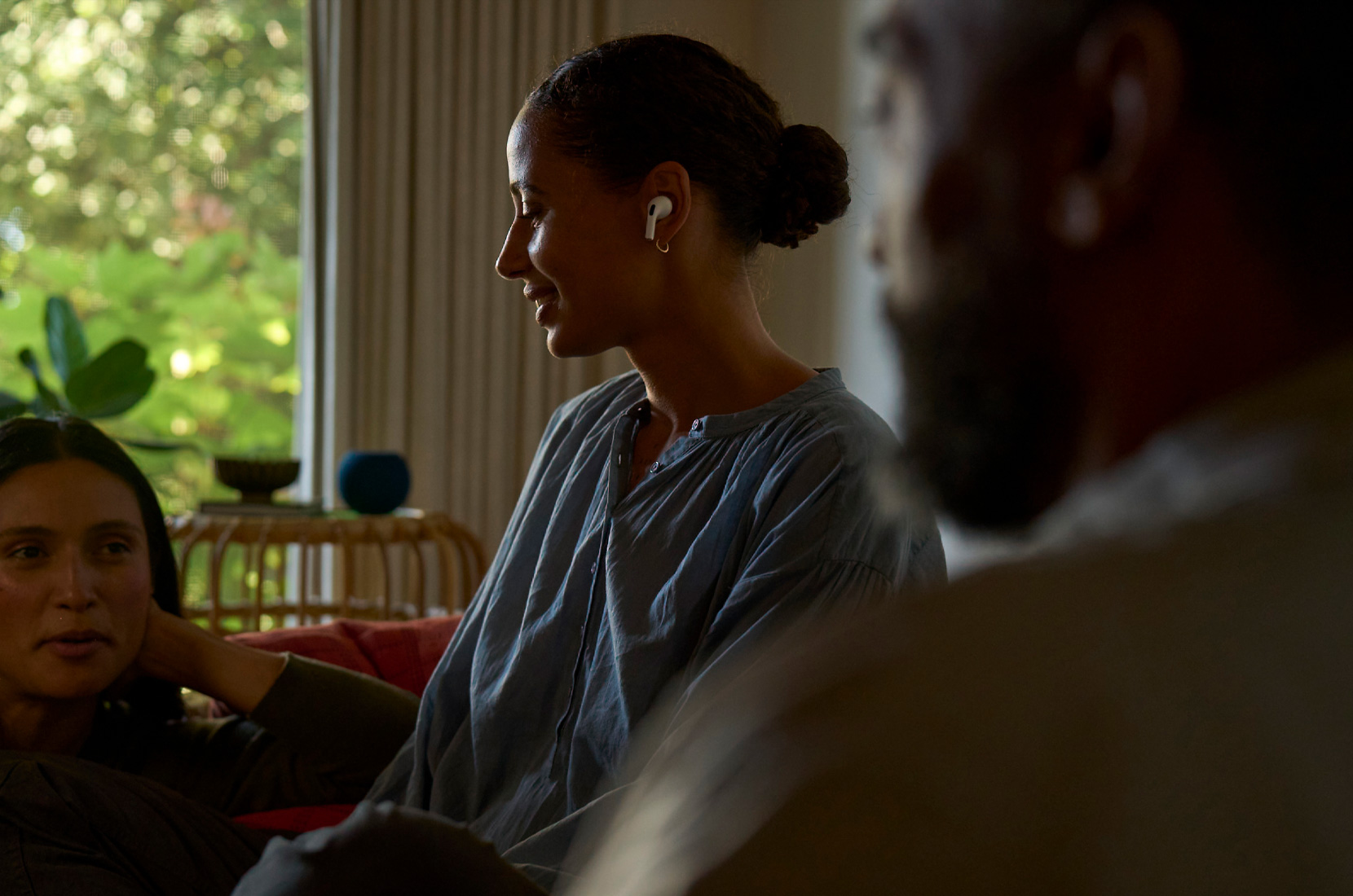 Ảnh chụp mặt nghiêng một phụ nữ đeo AirPods Pro 2 ở tai trái và sử dụng tính năng Sức Khỏe Thính Giác