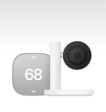 Apple Home Collection smart home thermostat, silver color, displaying temperature of 68 degrees, Apple Home Collection smart home camera, black lens and surround mounted on a white stand and arm