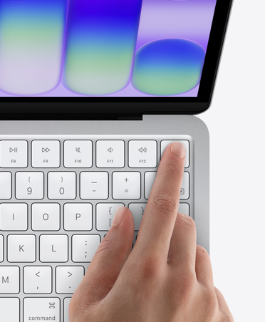 MacBook Neo color argento con il dito di una persona appoggiato sul sensore Touch ID nell’angolo in alto a destra della tastiera
