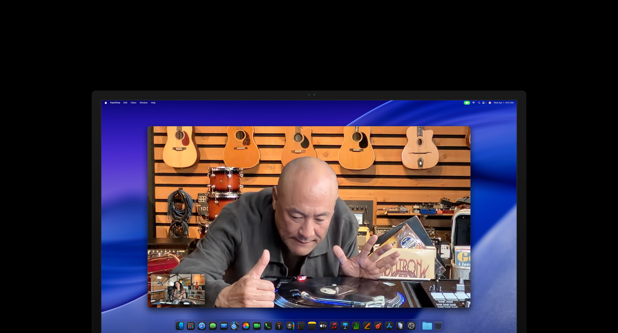 While on a video call, a person at a music store looks closely at a turntable, he remains centered in the frame thanks to the Center Stage camera