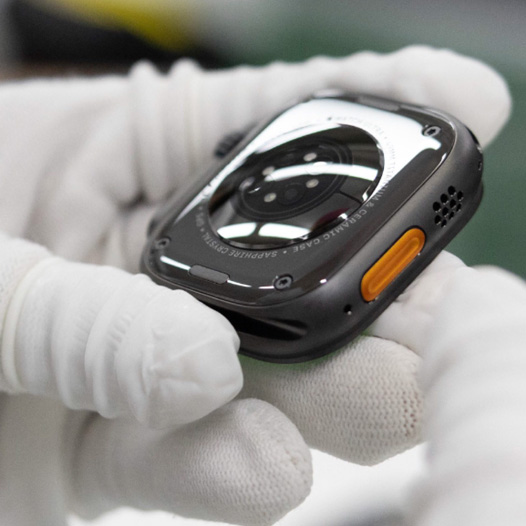 장갑을 낀 손으로 Apple Watch의 본체를 뒷면이 위로 향하게 잡고 있는 모습